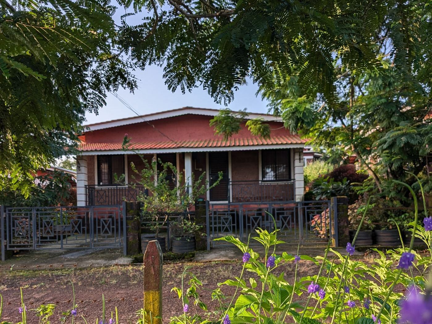 A bungalow at 1000 Trees Holiday Homes, Dapoli, framed by trees and flowering plants